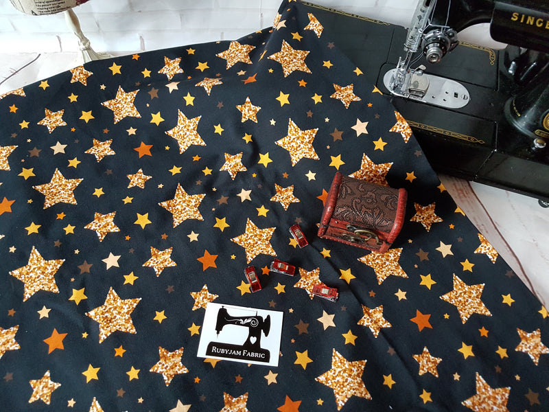 Gold Stars on Black - cotton lycra - 150cm wide