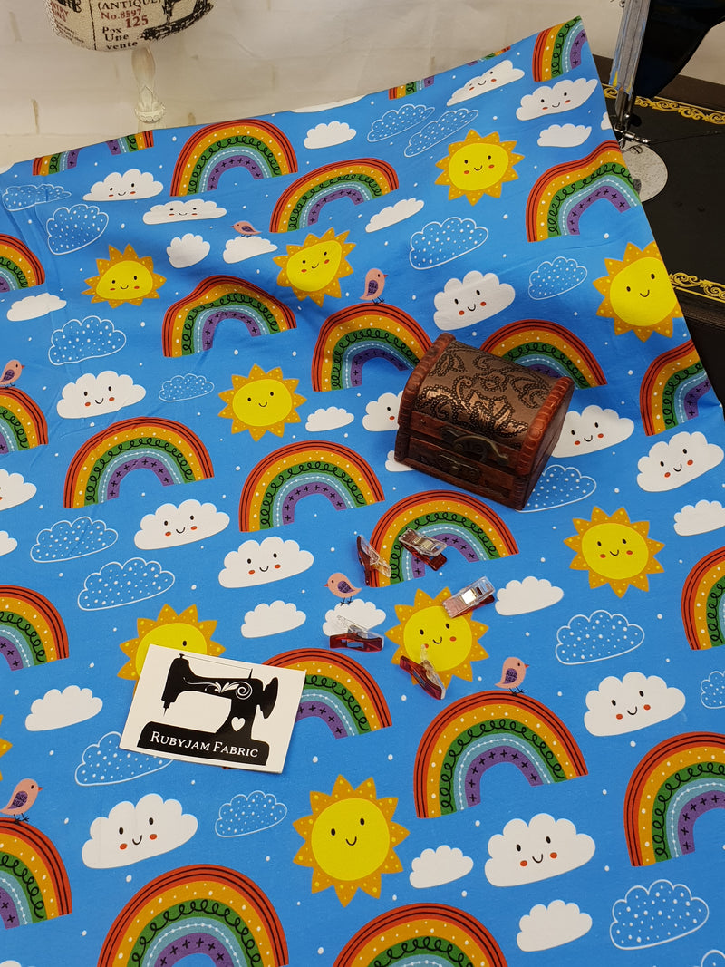 Happy Days, Rainbows on Blue - cotton lycra - 150cm wide