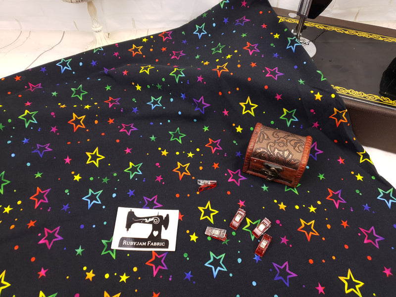 Multicoloured Stars on Black - cotton lycra - 150cm wide - clearance